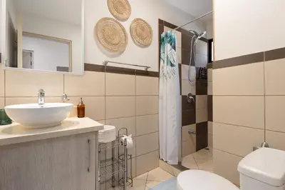 a bathroom with a sink and a toilet and a shower at Two Palms Ground Floor Unit Across from Beach in Coco