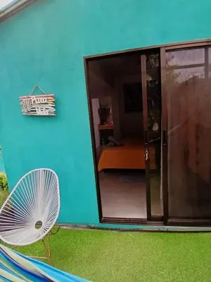 a blue house with a fan next to a window at SJO Green Casita in Santiago Este