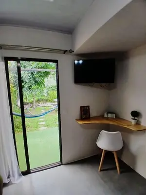 a room with a window and a tv and a chair at SJO Green Casita in Santiago Este