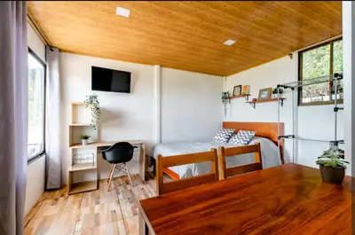 a room with a bed and a table in a room at CANTO DEL RIO-Rivas- vista a la montaña- tranquilo in Rivas