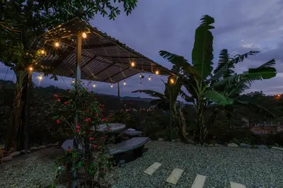 a patio with a bench and an umbrella and lights at CANTO DEL RIO-Rivas- vista a la montaña- tranquilo in Rivas
