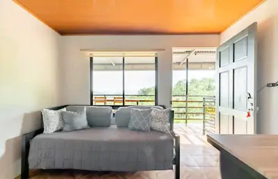 a living room with a couch in front of some windows at CANTO DEL RIO-Rivas- vista a la montaña- tranquilo in Rivas