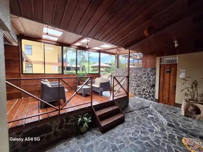 a lobby with a staircase and some chairs at Hotel Iris Arenal in Fortuna