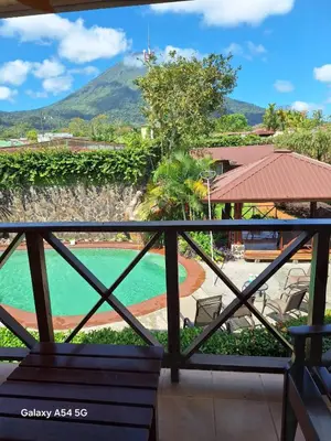 a view of the pool from the balcony of a resort at Hotel Iris Arenal in Fortuna