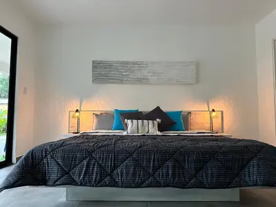 a bedroom with a large black bed with two lamps at Hotel Good Life in Coco