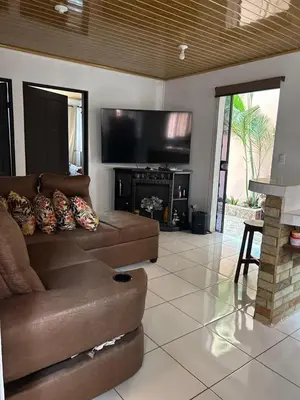 a living room with a couch and a flat screen tv at Apartamento Caribe Rosa in Puerto Limón