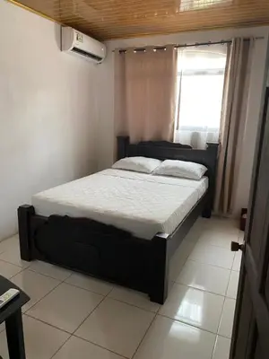 a bedroom with a bed in a room with a window at Apartamento Caribe Rosa in Puerto Limón