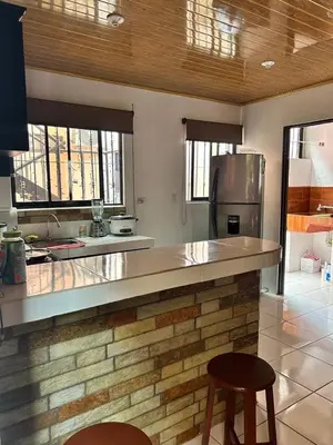 a kitchen with a counter and a refrigerator at Apartamento Caribe Rosa in Puerto Limón