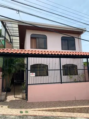 a pink and white house with a gate at Apartamento Caribe Rosa in Puerto Limón