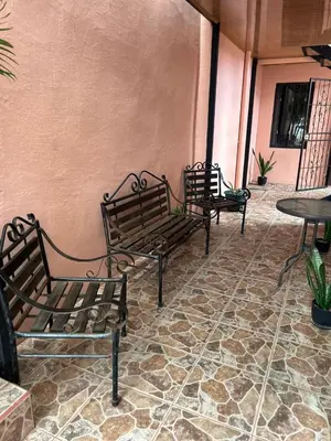 three benches sitting on a patio with a table at Apartamento Caribe Rosa in Puerto Limón