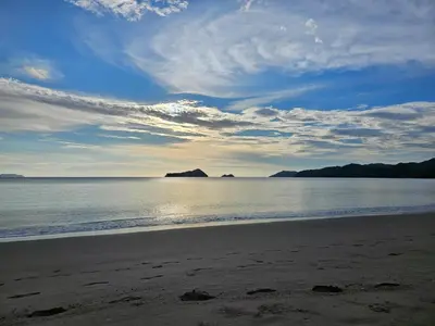 a beach with a cloudy sky and the ocean at Casona Cocobolo el mejor lugar de Costa Rica in Guanacaste