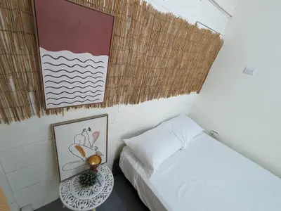 a small bedroom with a bed and a table at Hostel Los Pargos in Río Sequito
