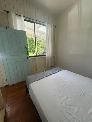 a white bedroom with a bed and a window at Hostel Los Pargos in Río Sequito