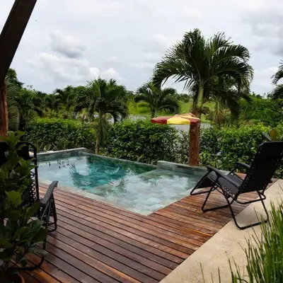 a pool on a wooden deck with two chairs and an umbrella at Casa Amanecer Familiar Hotel Ecopaisajes in Río Cuarto