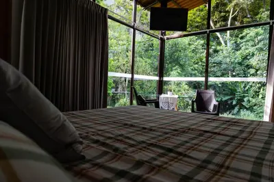 a bedroom with a bed and a large window at Casa Amanecer Familiar Hotel Ecopaisajes in Río Cuarto