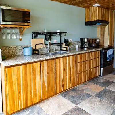 a kitchen with wooden cabinets and a counter top at Casa Amanecer Familiar Hotel Ecopaisajes in Río Cuarto
