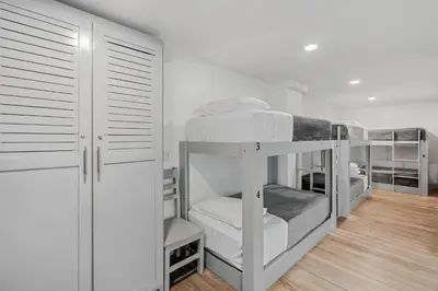 a room with three bunk beds and a closet at Iguana Surf Camp in Tamarindo