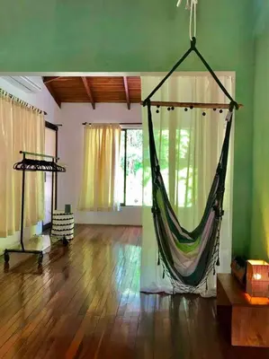 a room with a hammock hanging in a room at Lofty, fully equipped apartment in the heart of Montezuma in Puntarenas