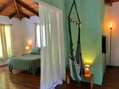 a bedroom with a bed and a room with at Lofty, fully equipped apartment in the heart of Montezuma in Puntarenas