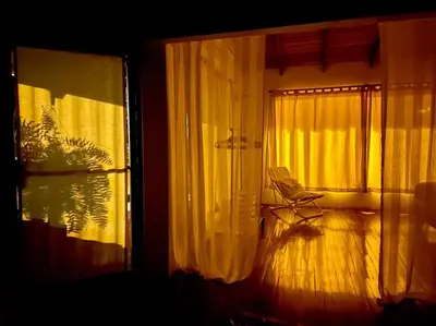 a room with a chair next to a window at Lofty, fully equipped apartment in the heart of Montezuma in Puntarenas