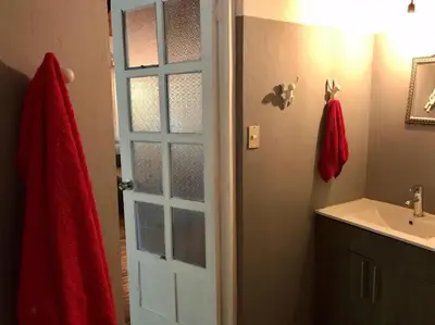 a bathroom with a white sink and a door at Lofty, fully equipped apartment in the heart of Montezuma in Puntarenas