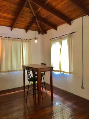 a dining room table with two chairs and a window at Lofty, fully equipped apartment in the heart of Montezuma in Puntarenas