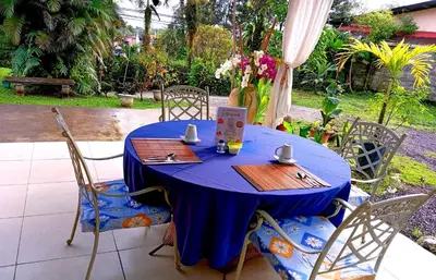 a table with a blue table cloth and chairs at Hotel Tierra De Volcanes in Fortuna