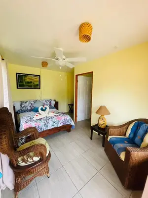 a bedroom with a bed and two chairs and a couch at Hotel Tierra De Volcanes in Fortuna