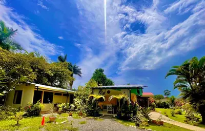 a house under a blue sky with clouds at Hotel Tierra De Volcanes in Fortuna