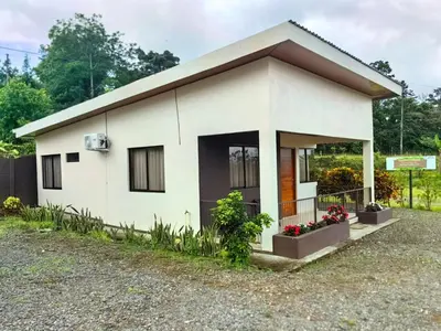 a small white house in a yard at Casita el Corral in Nuevo Arenal