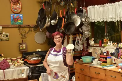 a woman standing in a kitchen holding a mushroom at Santuario Ecologico Monteverde in Monteverde Costa Rica