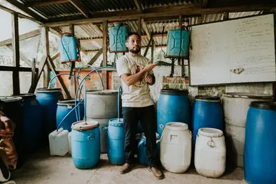 a man standing next to a bunch of blue barrels at Santuario Ecologico Monteverde in Monteverde Costa Rica