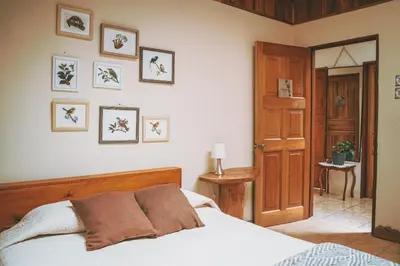 a bedroom with a bed and some pictures on the wall at Santuario Ecologico Monteverde in Monteverde Costa Rica