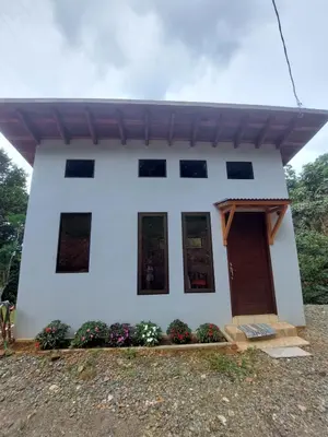 a white house with windows and a door at La cabaña del Dulce in San Rafael Norte