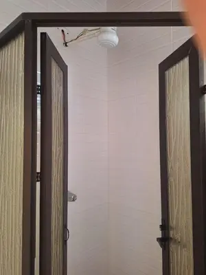 a bathroom with a shower with a door open at La cabaña del Dulce in San Rafael Norte