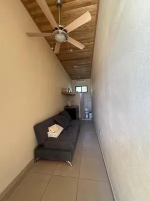 a living room with a couch and a ceiling fan at La Laguna in Nosara