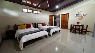 a bedroom with two beds and a table in it at Chirripó Oasis in Canaán