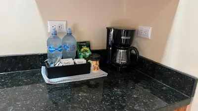 a counter with two bottles of water and a coffee maker at Chirripó Oasis in Canaán