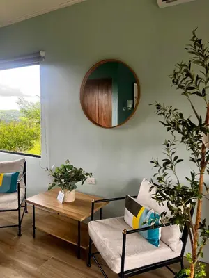 a living room with a table and chairs and a mirror at Paraíso privado Arenal Dragonfly in Fortuna