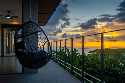 a swing hanging from a balcony with a sunset at Villa Vista Del Mar - by Pura Villas in Dominical