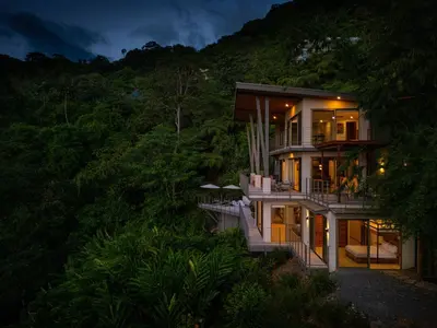 a house on the side of a hill at night at Villa Vista Del Mar - by Pura Villas in Dominical