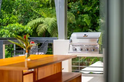 a kitchen with a grill on a screened in porch at Villa Vista Del Mar - by Pura Villas in Dominical
