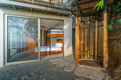 a house with a glass door with a bed in it at Villa Vista Del Mar - by Pura Villas in Dominical