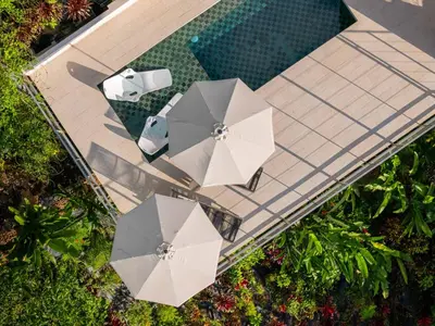 an overhead view of a swimming pool with umbrellas and a swimming pool at Villa Vista Del Mar - by Pura Villas in Dominical