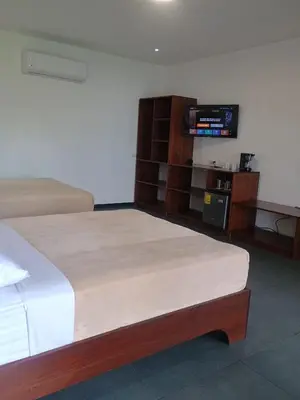 a hotel room with a bed and a tv at Scala Inn in Muelle