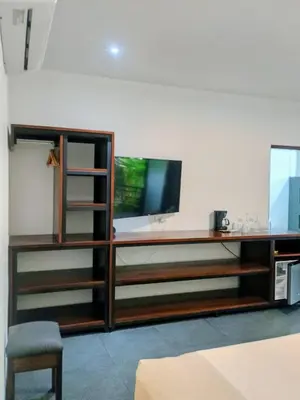a living room with a tv and a wooden entertainment center at Scala Inn in Muelle