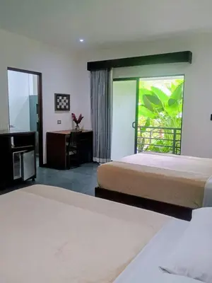 a hotel room with two beds and a window at Scala Inn in Muelle