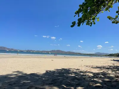 a beach with people walking on the sand at Villa Maravilla Estates, Tamarindo Beach, Prime Location, Family & Friends in Tamarindo