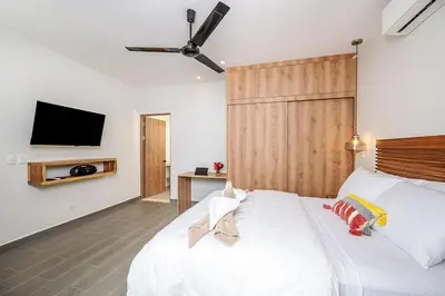 a bedroom with a white bed with a tv on the wall at Villa Maravilla Estates, Tamarindo Beach, Prime Location, Family & Friends in Tamarindo