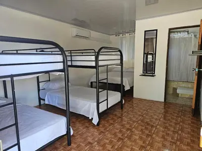 a room with three bunk beds and a mirror at Hotel Luna Liberiana in Liberia